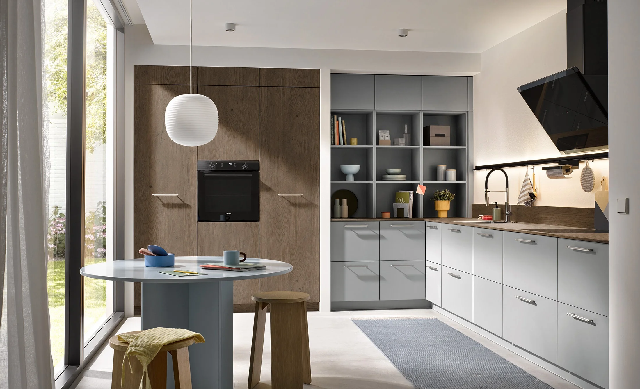 Burger Küchen – helle Küchenzeile in Weiß mit Holzarbeitsplatte und Sitzbereich